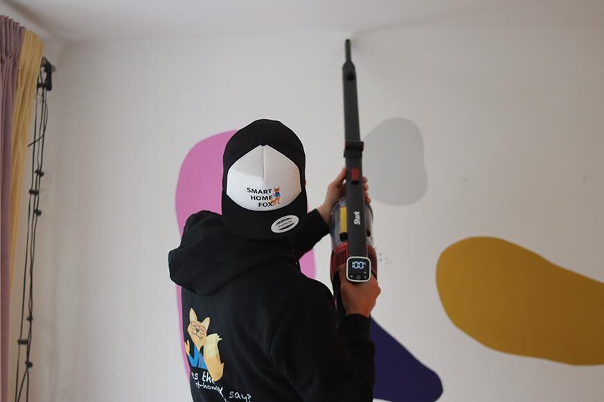 Shark Anti Hair Wrap is seen cleaning the edges of a blanket. 